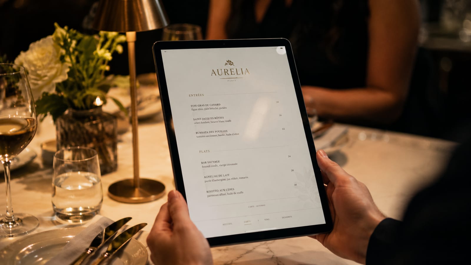 Carta digital de un restaurante en una tablet, sobre la mesa de un comedor de noche